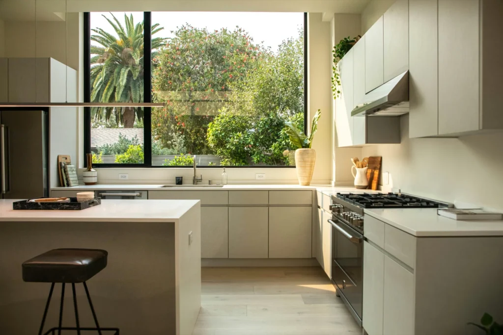 Cocina blanca con office y ventanal al jardín en un piso de Nervión